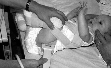 طفل يرتدي جهاز للحفاظ على المفصل أثناء عمل موجات صوتية