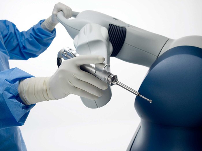 الجراح يحرك يد الروبوت اثناء جراحة المفصل الصناعي
