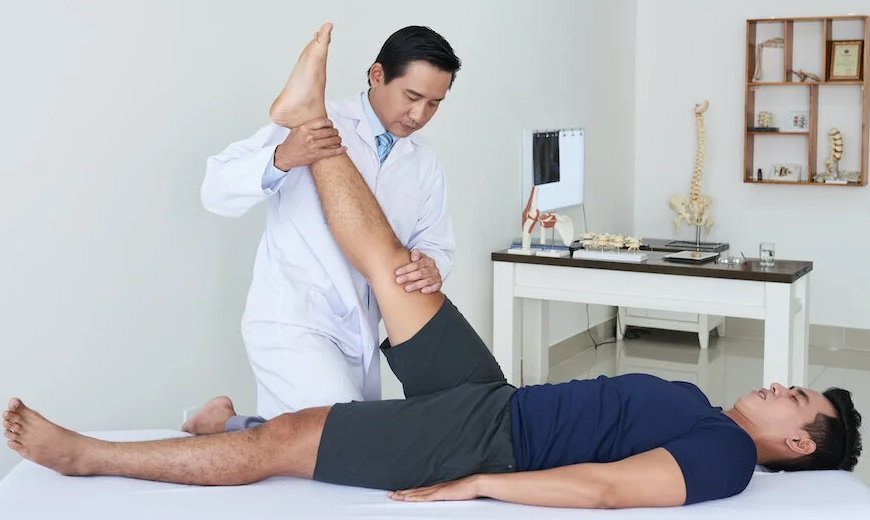 يقوم طبيب العلاج الطبيعي بعمل تمرينات علاجية بعد جراحة الرباط الصليبي